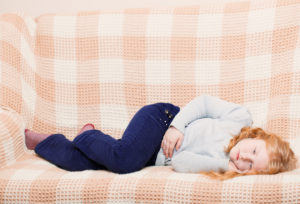 A girl with stomach bug on sofa