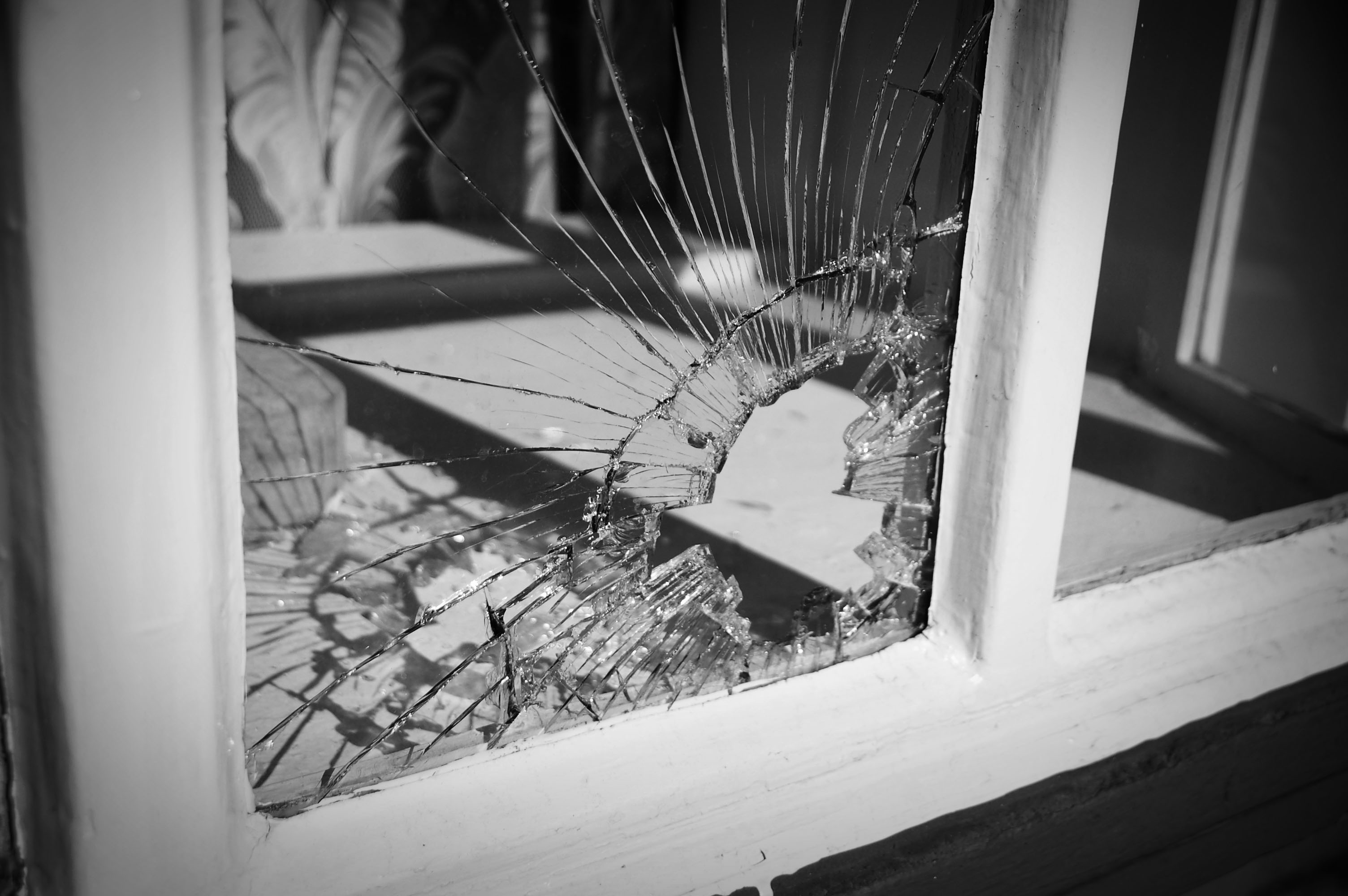 Black-and-white close-up of a shattered window pane