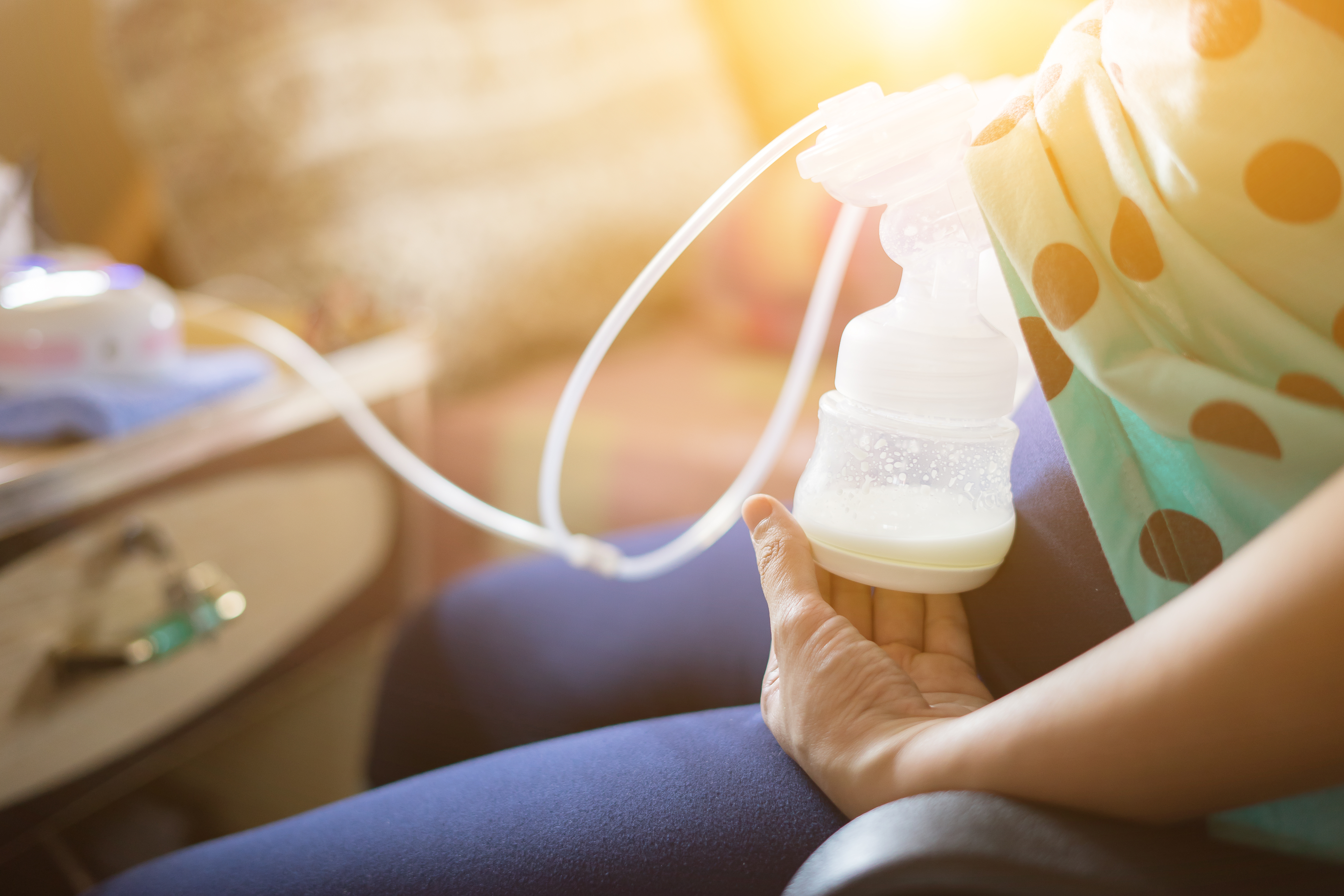 Close-up of an electric breast pump bottle filling with milk